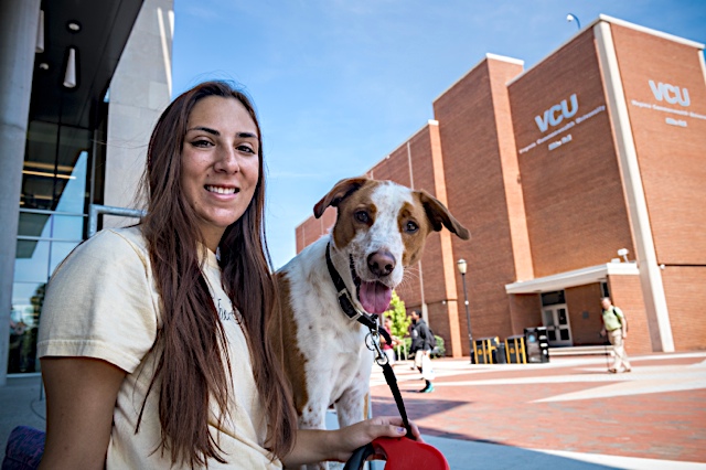 A dog and student hanging out at VCU's compass